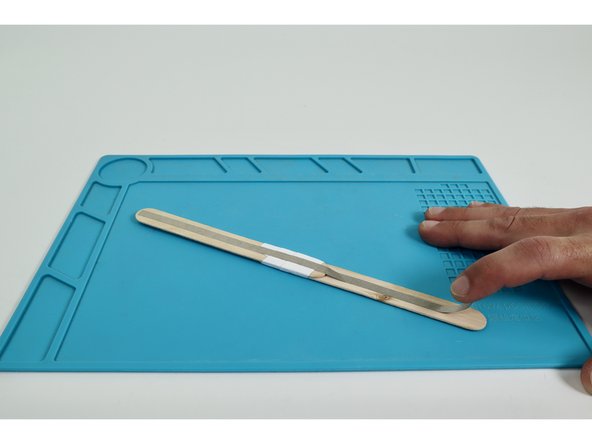 Place each of the two long Maker Tape pieces so they run end-to-end down the middle of each side of the wand handle.