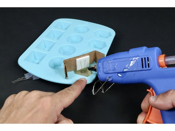 Using clear hot glue and a hot glue gun, squirt liquified hot glue into the mold until the glue covers the entire bulb.