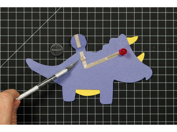 Since Maker Tape is conductive on both sides you can use it to make a tape loop that helps hold your battery in place.