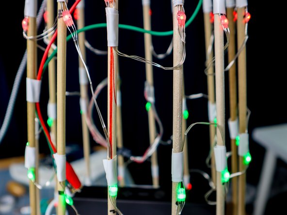 Tape an LED to each dowel, then move to the next one horizontally to make a full ring, then jump down to the next row and go around again until you've placed all 98 pixels.