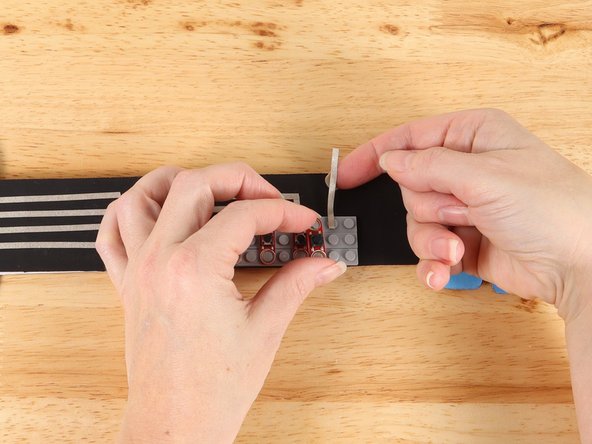 Lift up the last button and use a small piece of Maker Tape to start a path straight out from the button as pictured. 