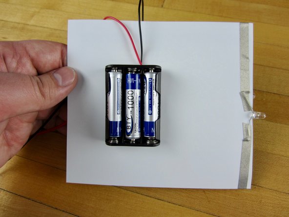 Use some double sided tape, or a tape loop, to tape the battery pack to the back of your template.