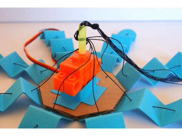 Make sure the tentacle are all fully extended, then tie a big knot where the threads exit from the straw