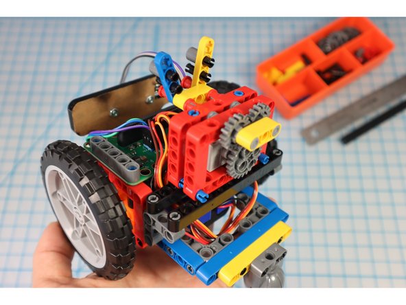 Add the arm gear assembly to the pins as shown.