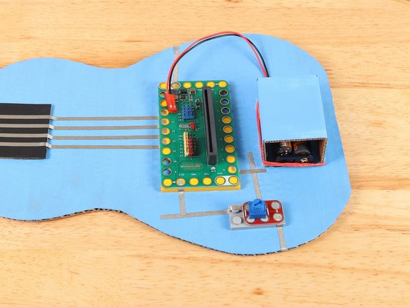Add a piece of Maker Tape under the 3.3v hole of the Bit Board that connects to the path from the Potentiometer. Press the Bit Board on top of the path to secure the tape in place.