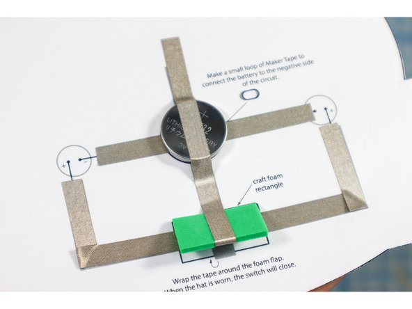 Place the battery on top of the loop of tape with the positive side up.