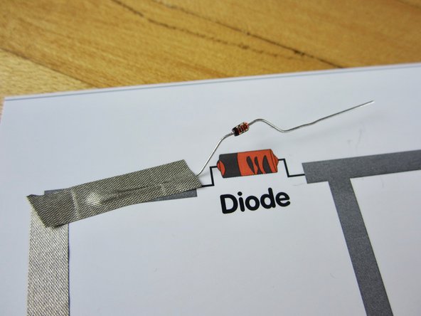 Lay tape down over the red, positive, wire from your solar cell.