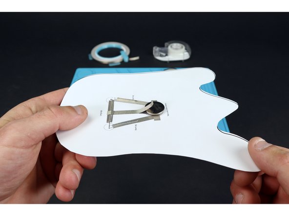 Peel and stick the longer piece of Maker Tape so that it contacts path &quot;B&quot; on one end and the top of the battery on the other end. This will turn your LEDs on! Simply peel back to turn them off.