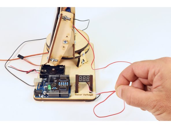 Twist the copper strands from the red wire of the solar panel to the strands from both the red and white wires of the voltmeter.
