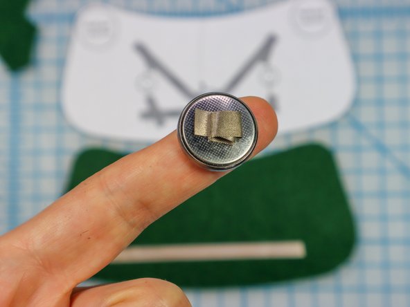 Make a loop of Maker Tape with the adhesive side out and place it on the negative side of the battery.