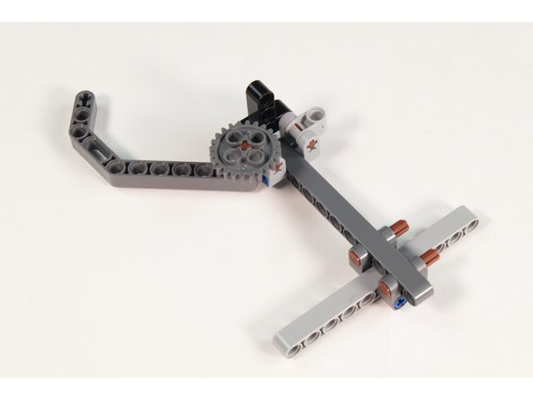 Slide the axle up through the hole in the LEGO Technic Beam 3 x 3.8 x 7 Beam Bent 45 Double.