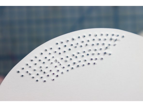 Using an awl, poke out all the tiny holes according to the template. To make it easier, use an old piece of cloth under the paper to allow the awl more room to move through.