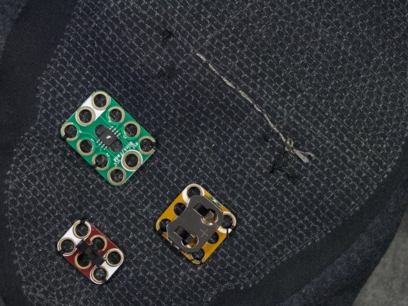 Turn the shirt inside out. Sew a running stitch to the location of the negative hole on the second led.