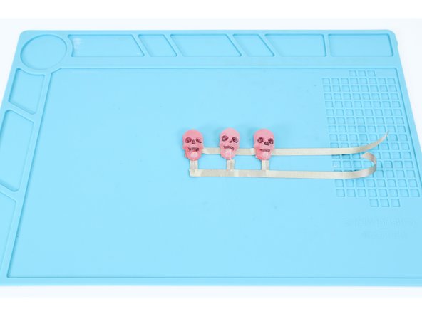 Now cut another 6&quot;-7&quot; section of Maker Tape and lay it over the top of the lower positive LED legs, connecting THEM in the same way you had connected the upper legs.