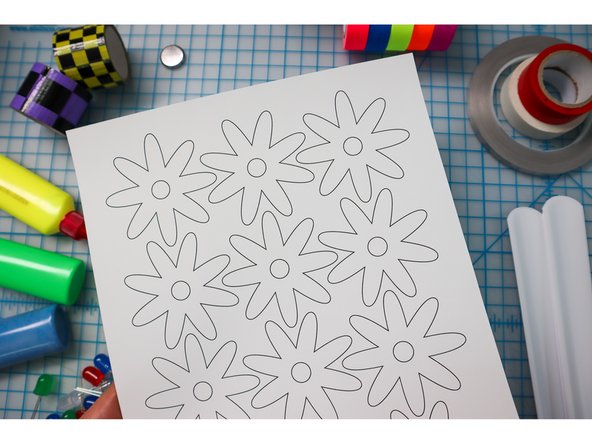 Choose an embellishment from the template and cut it out of foam, felt, paper, or fabric. Glue it over the LED(s).