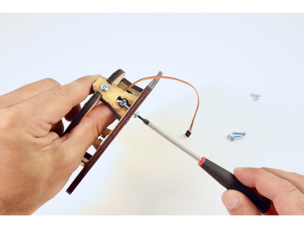 Fit the legs of the circular assembly into the slots of the engraved side of the base plate as shown.
