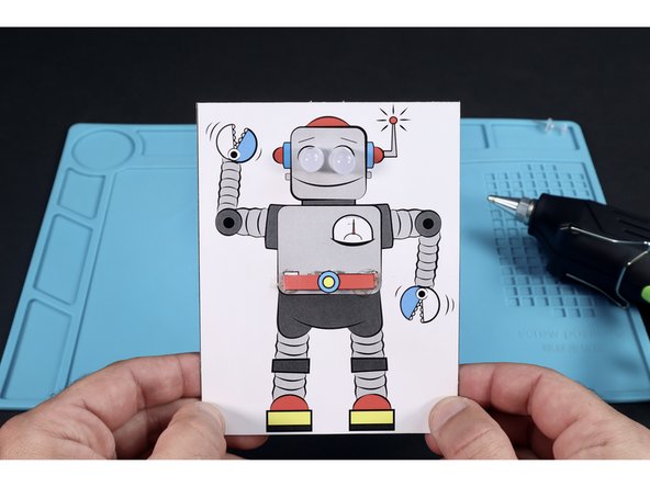 Repeat the process for the last tab so that the belt looks like the final photo. If done correctly, the conductive portion of the back will NOT lay flat against the rest of the card.  Pushing the buckle down into contact with the two small Maker Tape nubs will complete the circuit and turn the LED eyes on.