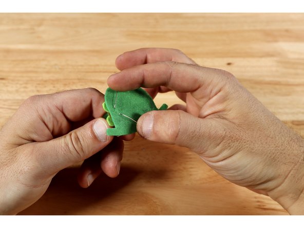 On the back side of the felt topper fold each leg flat and away from one another as shown.