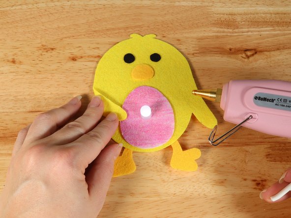 To make the Chick look like it is holding the egg, fold the wings inward and keep them in place with a small amount of hot glue.