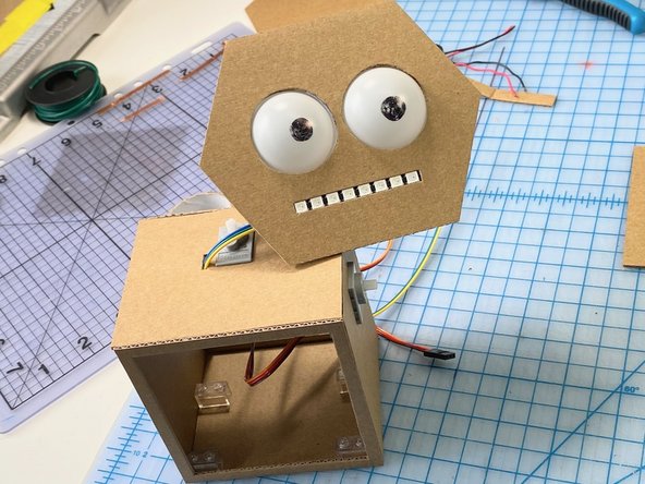 We also made a hole in the top, next to the servo, to allow the wires from the speakers and the LED mouth to enter the robot's body.