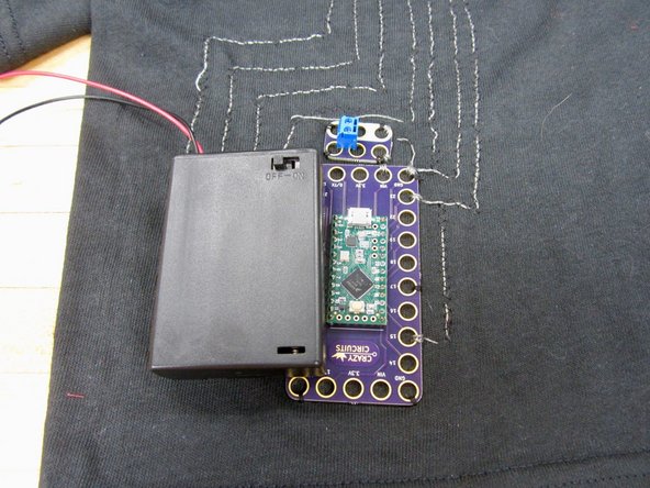 Cut a piece of fabric out and pin it to your shirt.