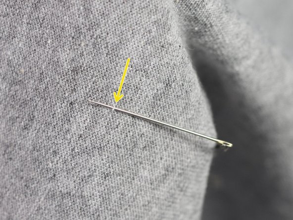 Run the thread to the negative side of the LED by picking up just one thread of the t-shirt material every half-inch. This will tack the thread in place and won't be visible from the front of the shirt.