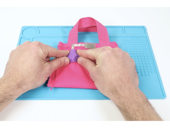 So that your battery doesn’t get knocked loose when putting things in your bag, cut and hot glue a small square of felt just a little bit bigger than your battery where shown.