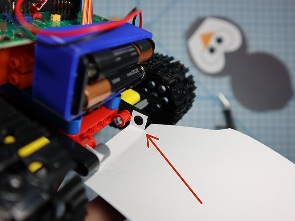 Place the folded paper between beams on the back of the Tank as shown.