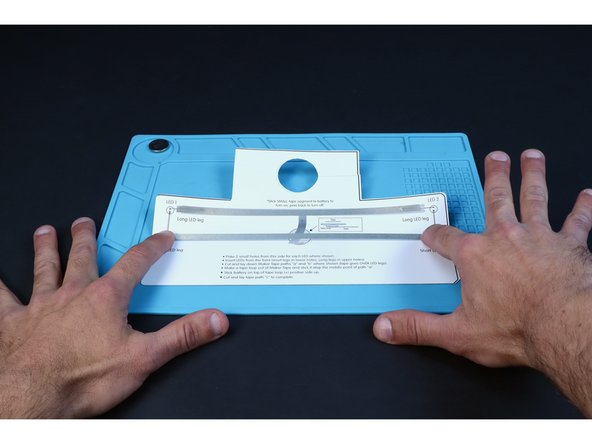Peel and stick the two longest Maker Tape pathways where shown on the diagram. The tape should go OVER the LED legs.