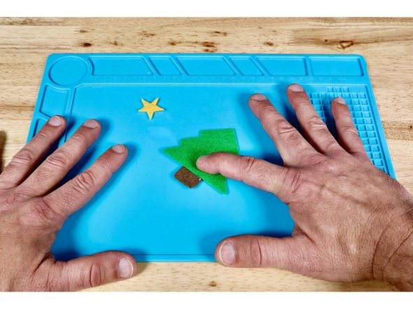 Press the foliage piece into place atop the hot glue on the trunk.