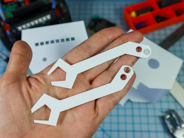 Use a hold punch to punch out the holes in the arms and the 4 holes on the body.