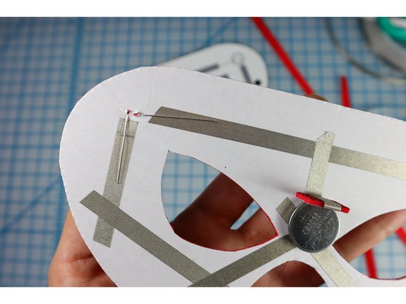 Push the LEDs all the way through, then bend the legs flat along the paths of the Maker Tape as shown.