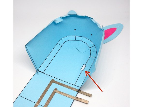 Glue the side so the tabs are on the inside of the body; they'll overlap on top of the ears