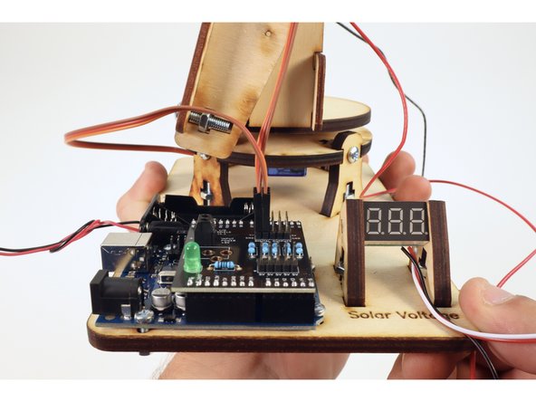 Take the wires from the lower servo and plug them into the row of pins labeled D5 as shown in photo two. Again, orient them so that the brown wire connects to the column of pins labeled "GND".
