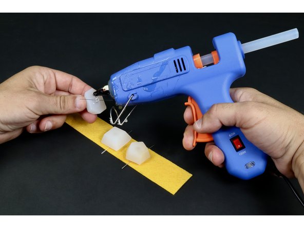 Put a dab of hot glue on the round bottom of the first LED and stick it in place to the felt. Note the position of the short LED leg and the long leg.