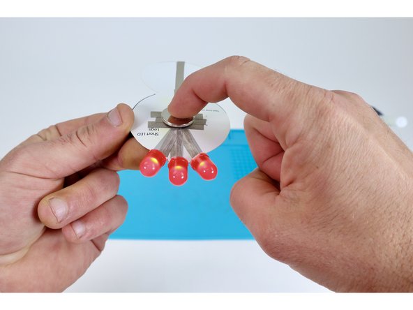 Now, peel &amp; stick Maker Tape segment “K” so one end connects to "G" and the other connects to the top of the battery. This completes the circuit and turns the LEDs on.