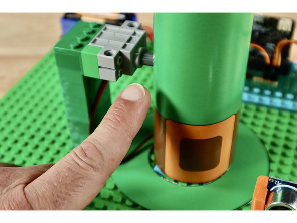 The final connection can be a little tricky to make. Be patient! You will need to connect the servo axle and the axle that is showing through the hole in the hat.