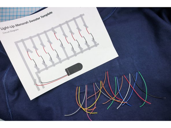 Follow the circuit diagram on the template to separate the wires, with one wire from each candle routed up and one routed down. Use masking tape to keep the wires in place.