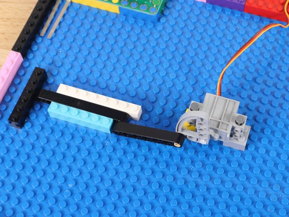 Surround the end of the LEGO Gate with LEGO bricks. This creates a track in which the gate can slide.
