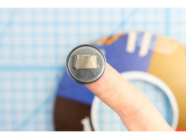 Make a loop of Maker Tape small enough to fit inside the black ring on the negative side of the battery, and stick it on. Place the ring and battery on the negative piece of tape.