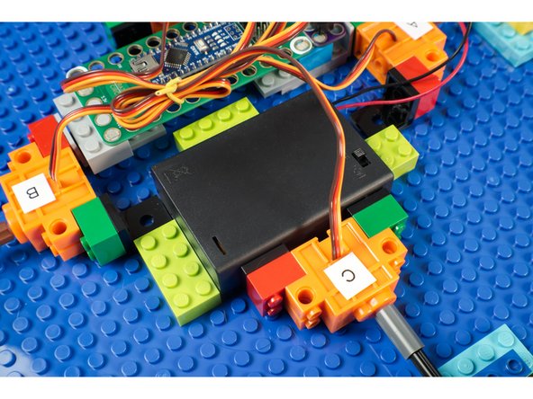 We used a few LEGO Bricks stuck down to the LEGO Baseplate to keep our Battery Pack in place and prevent it from sliding around while the robot is moving.