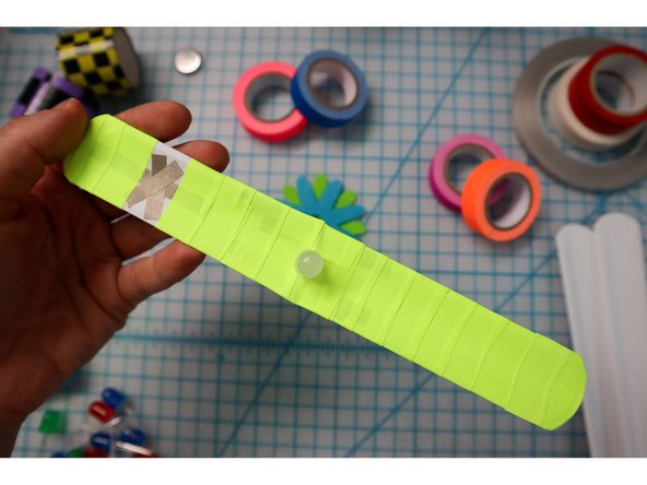 To embellish the band, wrap colorful tape around it, but don't cover the Xs!