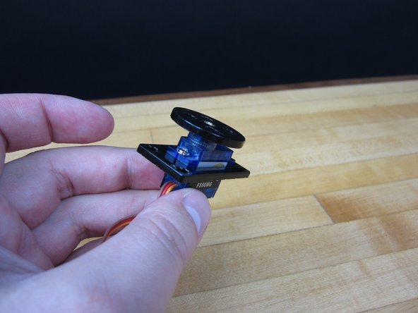 We're using a 9G Continuous Rotation Servo with some laser cut acrylic adaptors. We include those in our kits, but we also have those files available for download.