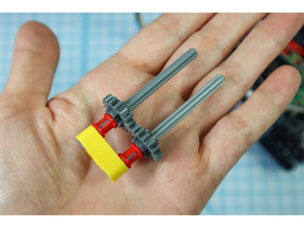 Push the pieces down until they stop, interlocking the gears.