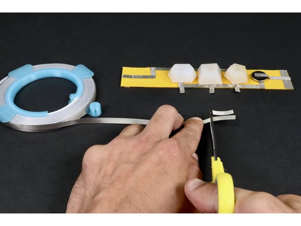 Cut two (final) small pieces of Maker Tape. and prepare a 1/2&quot;x 1/4&quot; piece of conductive hook and loop.