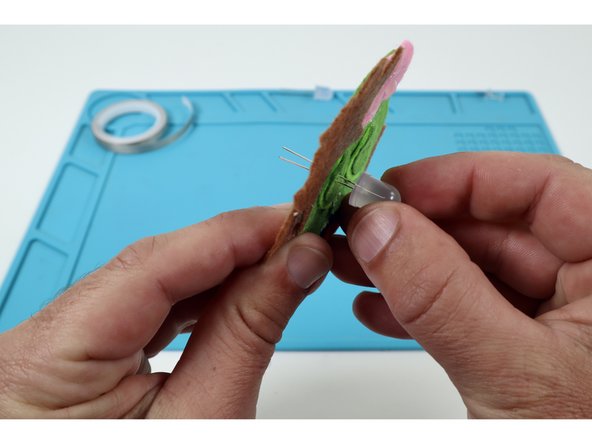 Thread  the two legs of one LED  through one of those pairs of holes. The orientation of the long and short LED legs doesn't matter for the first LED.