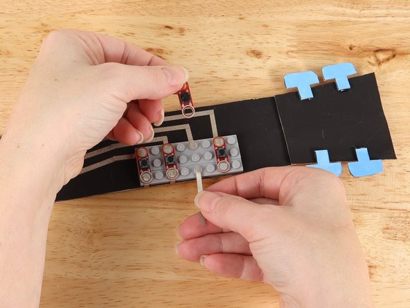 Remove the third button and add a piece of Maker Tape to the bottom stud as pictured.