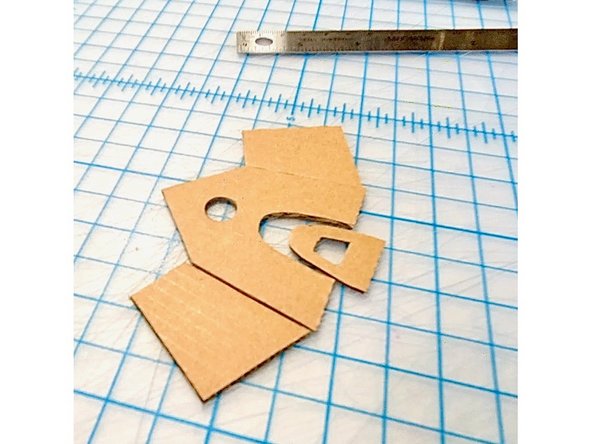 I made a tiny gingerbread house out of cardboard, with the chimney sized to fit the NeoPixels stick.