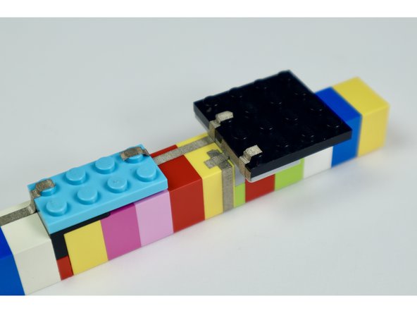 If you completed these last 4 small tape paths correctly, the end of your last segment should reach the first LEGO stud of the 4x4 LEGO plate with one stud-worth of space between it and the neighboring path.