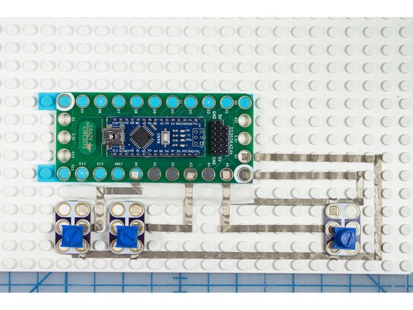 Place the Crazy Circuits components in place on top of the Maker Tape. We found some small LEGO tires that fit right over the pot knobs making them easier to turn!